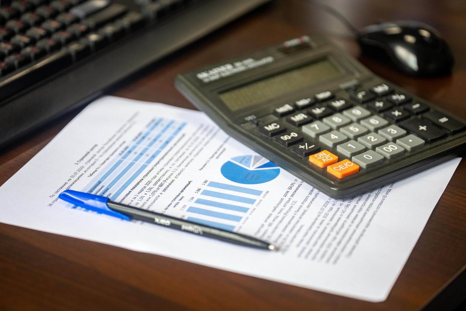 Financial report, calculator and pen on a desk